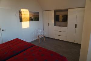 特拉森海德Ferienhaus Marny的一间卧室配有红色的床和电视