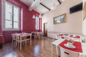 罗马含羞草万神殿酒店的一间带桌椅和红色墙壁的餐厅