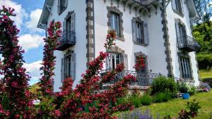 Saint-Cirgues-de-JordanneLa Maison Normande的前面有鲜花的白色房子