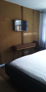 RehnaGästehaus 22 am Klostergarten的一间卧室配有一张床、一张书桌和一台电视。