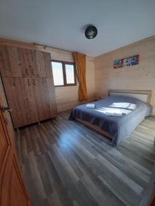 莱斯诺夫Casute la munte的一间卧室配有一张床,铺有木地板