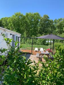 卡兰茨奥赫Casa Callantsoog的庭院配有遮阳伞和桌椅。