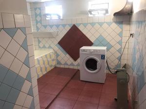 古达乌塔Tyulpan Vacation Home的一间带瓷砖墙的浴室内的洗衣机