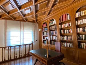 Olías del ReyVILLA BLANCA的一间设有桌子和书架的房间