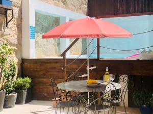 加亚新城Boreal Porto Gaia - Patio & Pool的露台上的一张桌子和一把红色遮阳伞