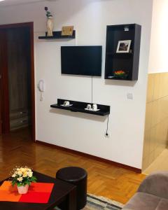 弗尔尼亚奇卡矿泉镇Apartmani Tamara的一间客厅,在白色的墙上配有电视