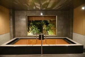 神户有马温泉 竹取亭丸山温泉旅馆的带窗户的客房内的热水浴池