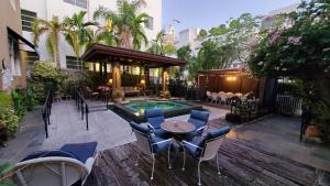 迈阿密海滩卡德特酒店的一个带桌椅的庭院和一个游泳池