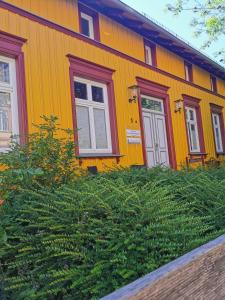 施特拉尔松德Sommerhaus Seidel - mit kostenlosem Parkplatz -的黄色和红色的房子,有两个窗户和灌木丛