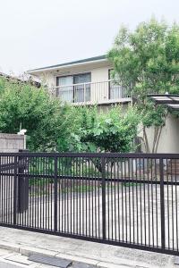 广岛Itsukaichi First Villa Hiroshima的房屋前的黑色铁栅栏