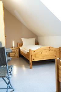纽奥本卢斯Ferienwohnungen Köhler的一间卧室配有一张木床和一把椅子