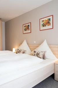 纽奥本卢斯Ferienwohnungen Köhler的卧室配有两张床,墙上挂有两张照片