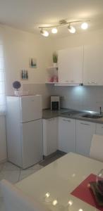 拉巴克Apartment Rosana的厨房配有白色橱柜和白色冰箱。