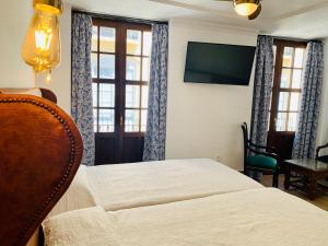 隆达唐米格尔酒店的一间卧室配有一张床和一台平面电视