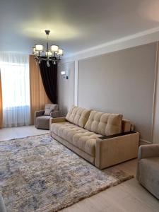 库斯塔奈2-ухкомнатная современная новая квартира в центре города的客厅配有大沙发和地毯。