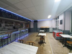 EspinassesHotel De La Poste的一间带桌椅的餐厅和一间酒吧
