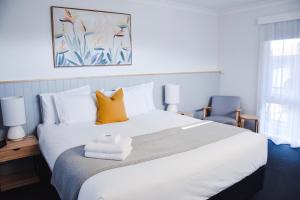 沃纳姆堡八斯班斯酒店的卧室配有一张带黄色枕头的大型白色床。