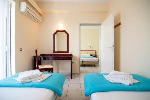 米提卡斯狄奥尼索酒店的一间卧室配有两张床、一个梳妆台和镜子