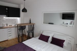 新瓦罗什Apartman Ena的一间带白色沙发的客厅和一间厨房