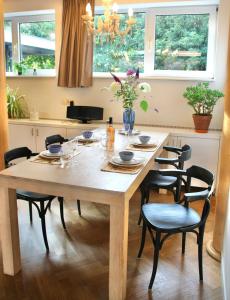 ZoelenDe Oude Kleuterschool的厨房里设有一张木桌,周围摆放着椅子