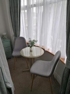 佩恩顿蓝色水域旅舍的客房设有桌子、两把椅子和窗户。