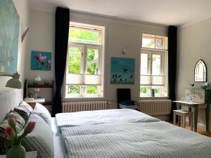 石勒苏益格Waldmühle的一间卧室设有两张床和两个窗户。