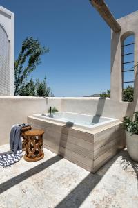 埃皮斯科皮·罗希姆诺Jasmine Holiday Villa的热水浴缸坐在房子的一侧