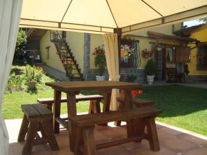坎加斯-德奥尼斯Apartamentos La Huerta de la Torre的一张野餐桌和一把伞下的长凳