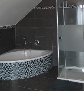 多瑙艾辛根Ferienwohnung Schwarzwald-Baar Blick的设有带浴缸和淋浴的浴室。