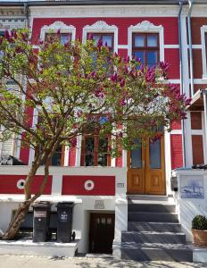 不莱梅Casa Feliz的一座红白的建筑,前面有一棵树