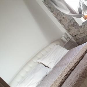 莫尔曼诺La Locanda dei Cavalieri的一张带白色床单和枕头的床