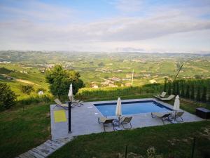 拉莫拉Locanda Fontanazza Osteria con Camere的山丘上带椅子和遮阳伞的游泳池