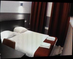 阿姆斯特丹莫纳法酒店的一间卧室配有一张带书桌的床和一张带毛巾的桌子。