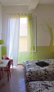 博洛尼亚Ottavo Portone的一间卧室设有一张床、一个窗口和一张桌子