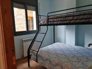 Sant Salvador de TolóApartaments Mitjavila的一间卧室配有双层床,梯子通往双层床