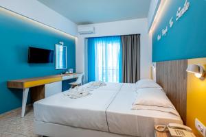 科斯镇奥林匹亚酒店的酒店客房设有一张大床和一张书桌。