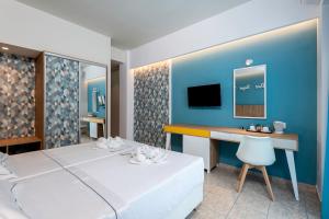 科斯镇奥林匹亚酒店的一间卧室配有一张床、一张书桌和一台电视。