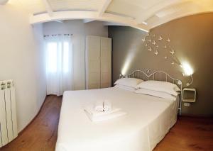 多尔切阿夸拉卡瑟塔迪瓦尔公寓的卧室配有白色床和2条白色毛巾