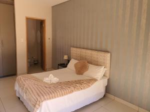 VryburgMaraba Manor的卧室配有一张带白色床单和枕头的大床。