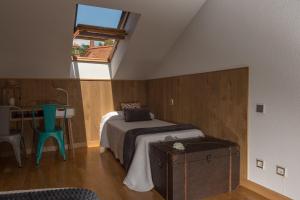 阿维拉Panorama Ático的一间卧室配有一张床、一张桌子和一个窗户。