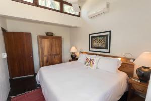 埃斯孔迪多港Villas Carrizalillo的卧室配有白色的床和木门
