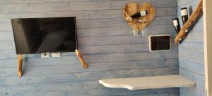 切尔韦泰里燧石花园住宿加早餐旅馆的蓝墙上的电视,带长凳和架子
