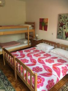 塞扎纳HOSTEL-SezanaLOKEV B&B的一间卧室配有两张双层床和花卉床罩