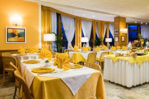 兰佐丁泰尔维米兰SNC酒店的宴会厅配有带黄桌床单的桌子