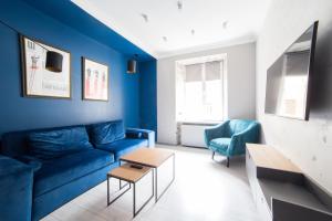 利沃夫Kraft Boutique Apart-Hotel的客厅配有蓝色的沙发和两把椅子