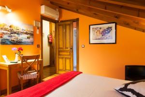 PámanesAlojamiento Bernabales的一间卧室设有橙色墙壁、一张床和一张书桌