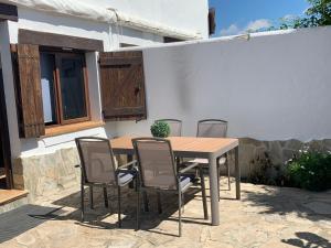 洛斯卡尼奥斯德梅卡Casa Rural Aldea Chica的天井上配有一张木桌和四把椅子