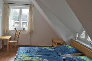 博恩Ferienhaus das Blaue Haus WS-9a的一间卧室配有一张床、一张桌子和一个窗户。