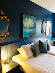 韦斯特波特The Waterside Apartment 112 Harbour Mills的一间卧室配有一张蓝色墙壁的床