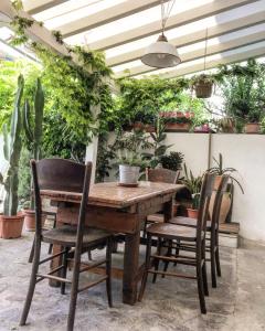 切塞纳蒂科Guest House CorteMazzini36的种有植物的庭院里摆放着木桌和椅子